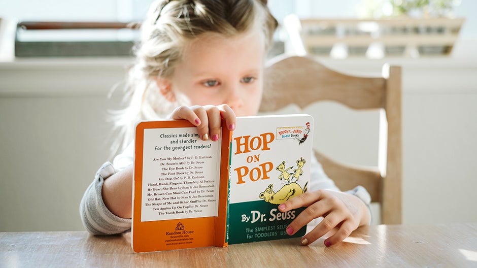 Little girl reading a picture book