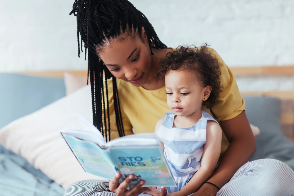 Child engaging in early literacy activities with books