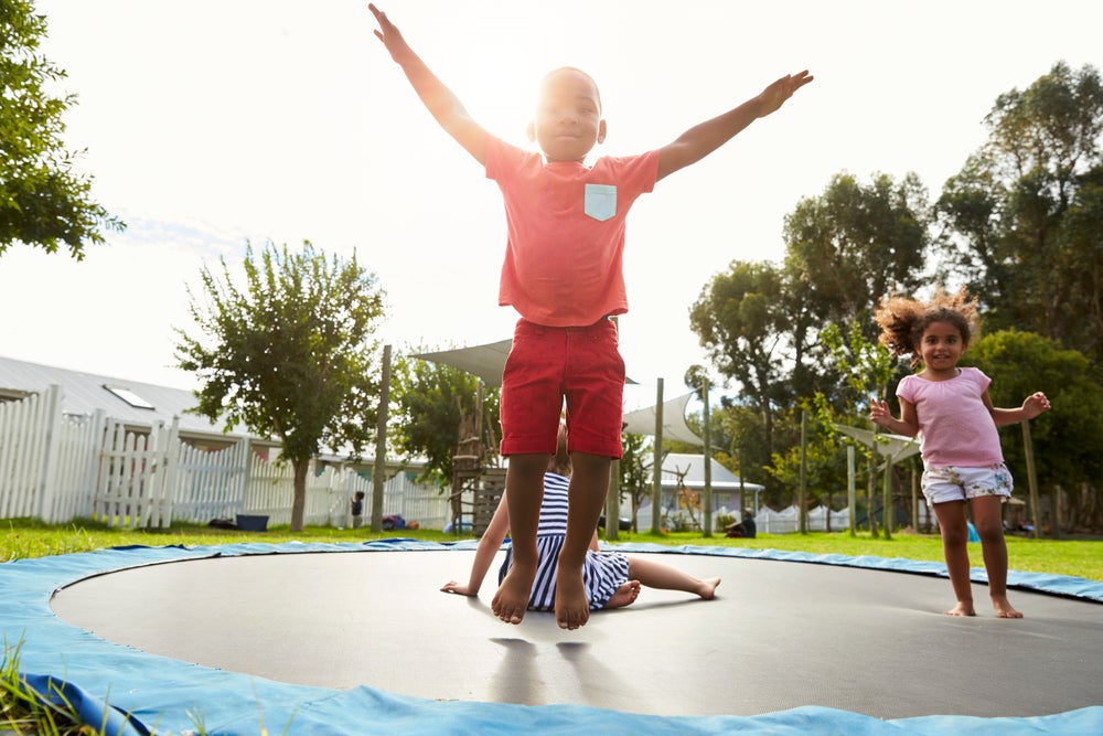 Children playing outside on trampoline