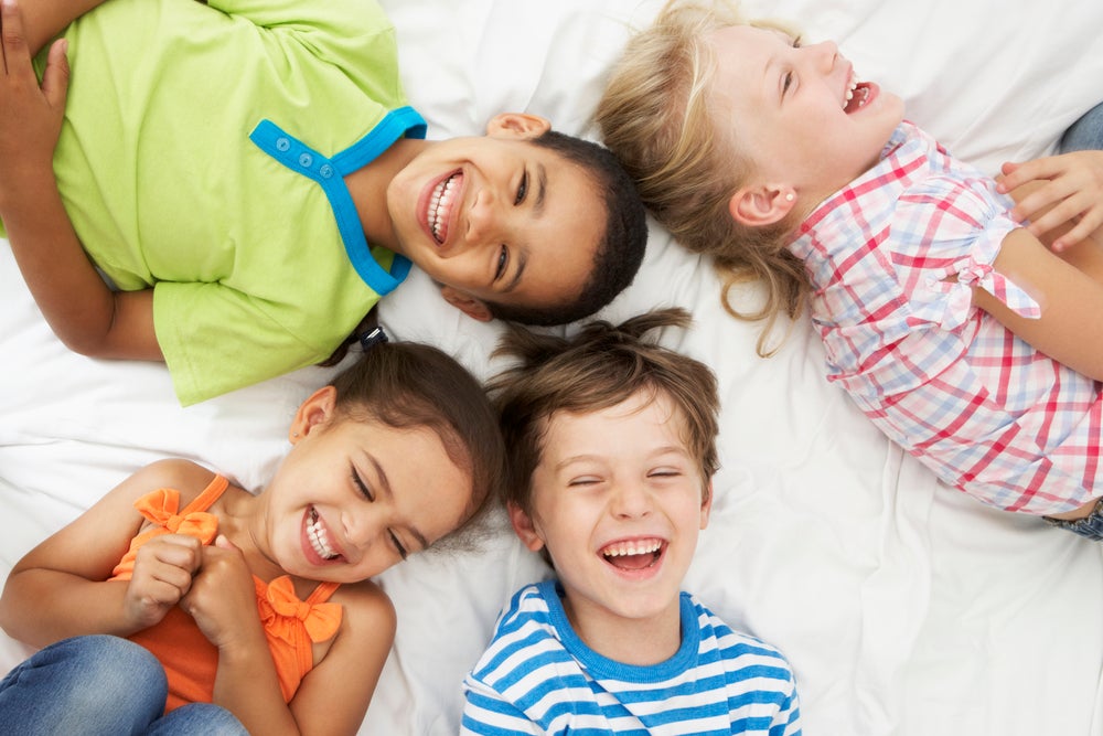 Group of kids laughing together on floor