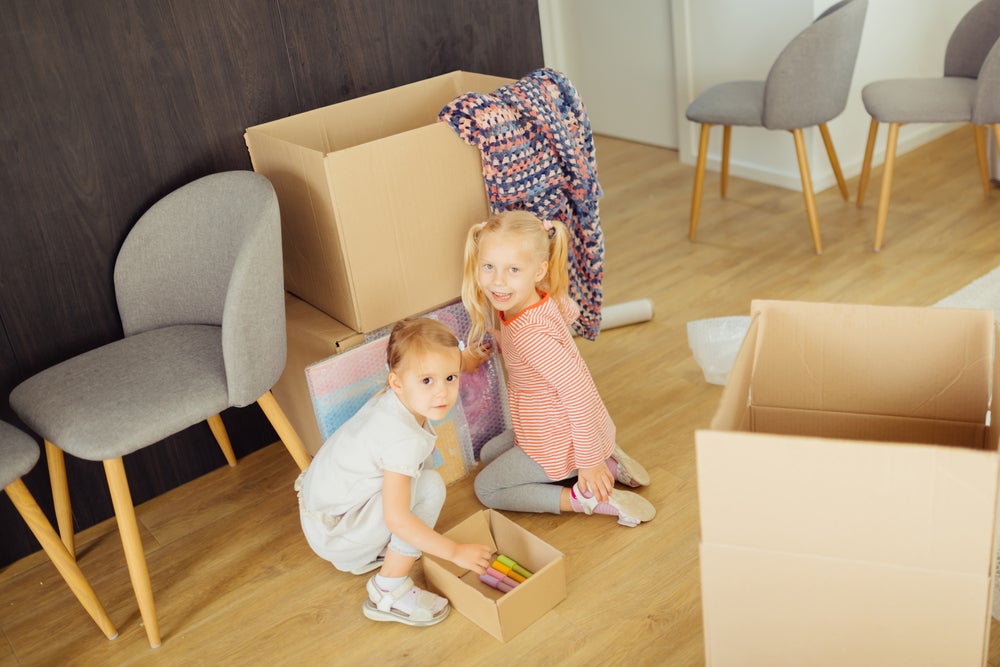 Two girls setting up an obstacle course on the floor