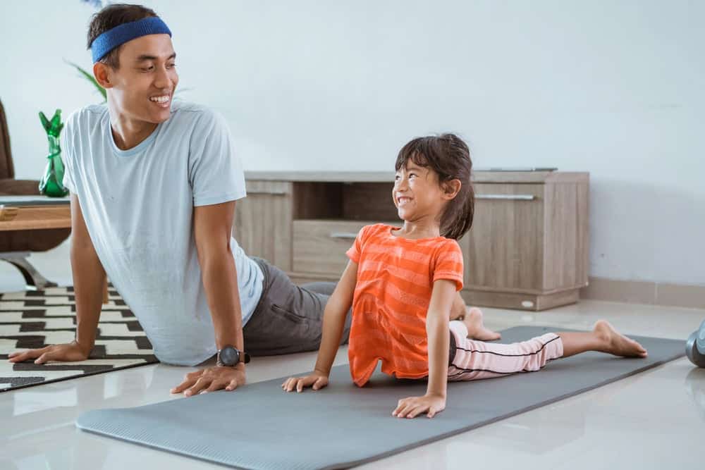 Dad doing yoga with child to teach mindfulness for kids