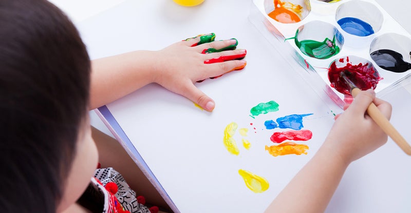 young kid painting to build confidence 
