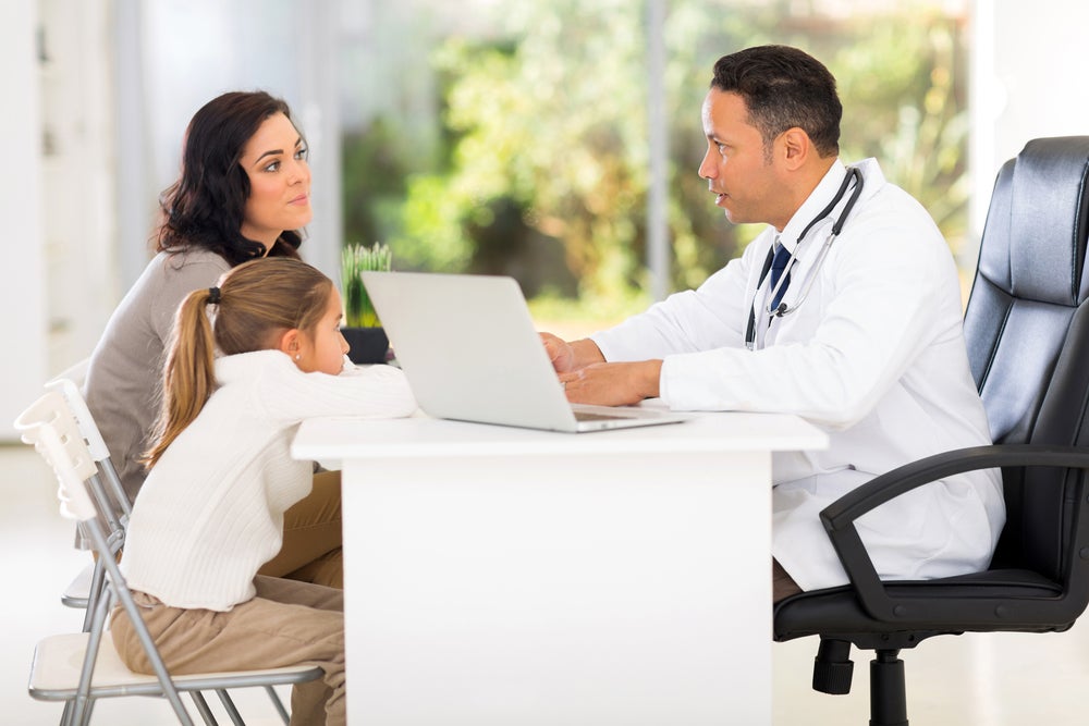 Mother and child consulting with doctor
