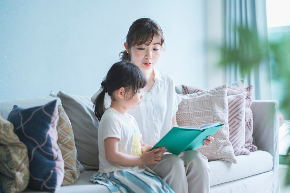 Mother reading book about feelings to daughter