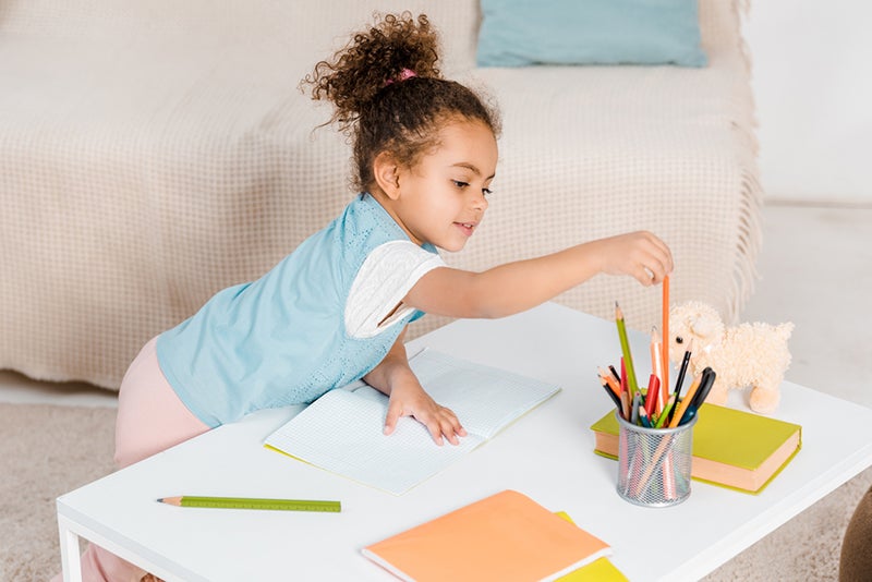 Girl grabbing pencil to get ready to make her own book