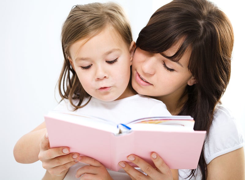 Mother reading book with her daughter