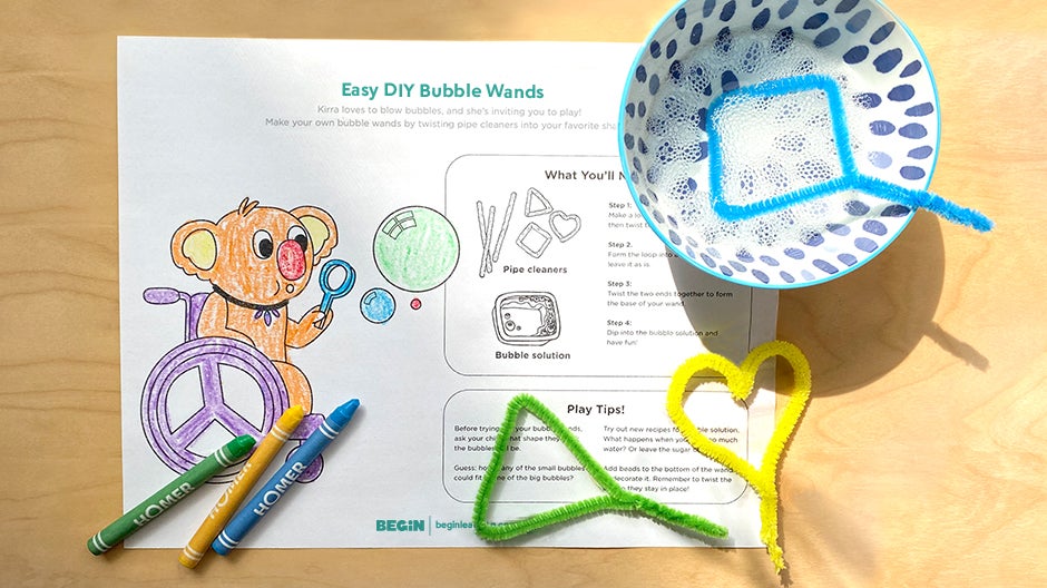 Completed DIY bubble wand printable, with crayons, bubble wands, and bowl containing bubbles on a table