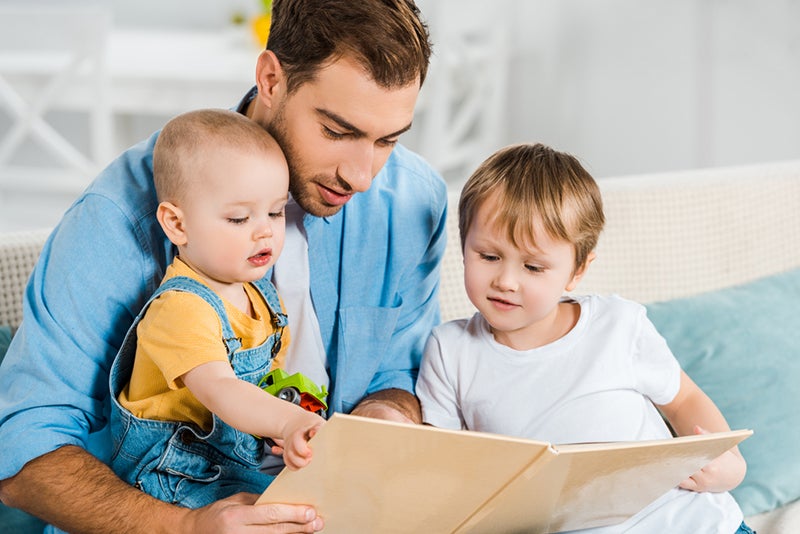 Parent reading to two young children