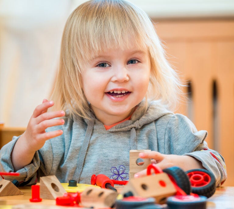 Two-year old girl playing with construction toys
