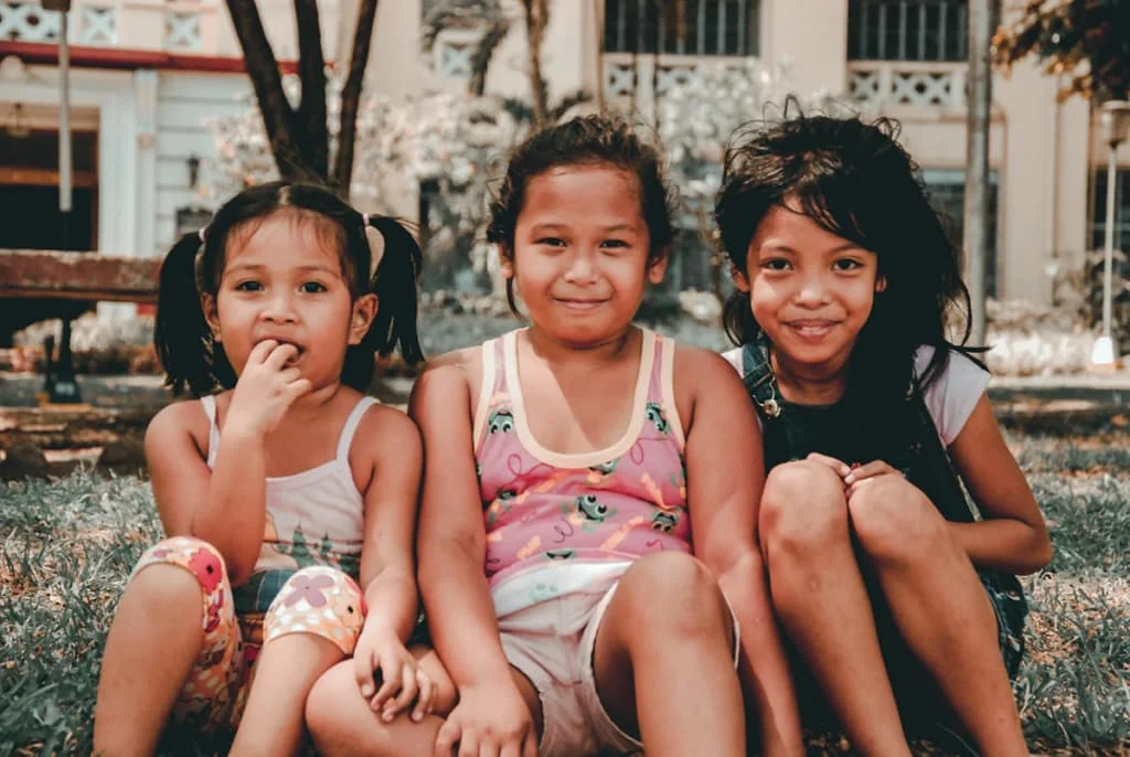 Three friends sitting outside on a curb