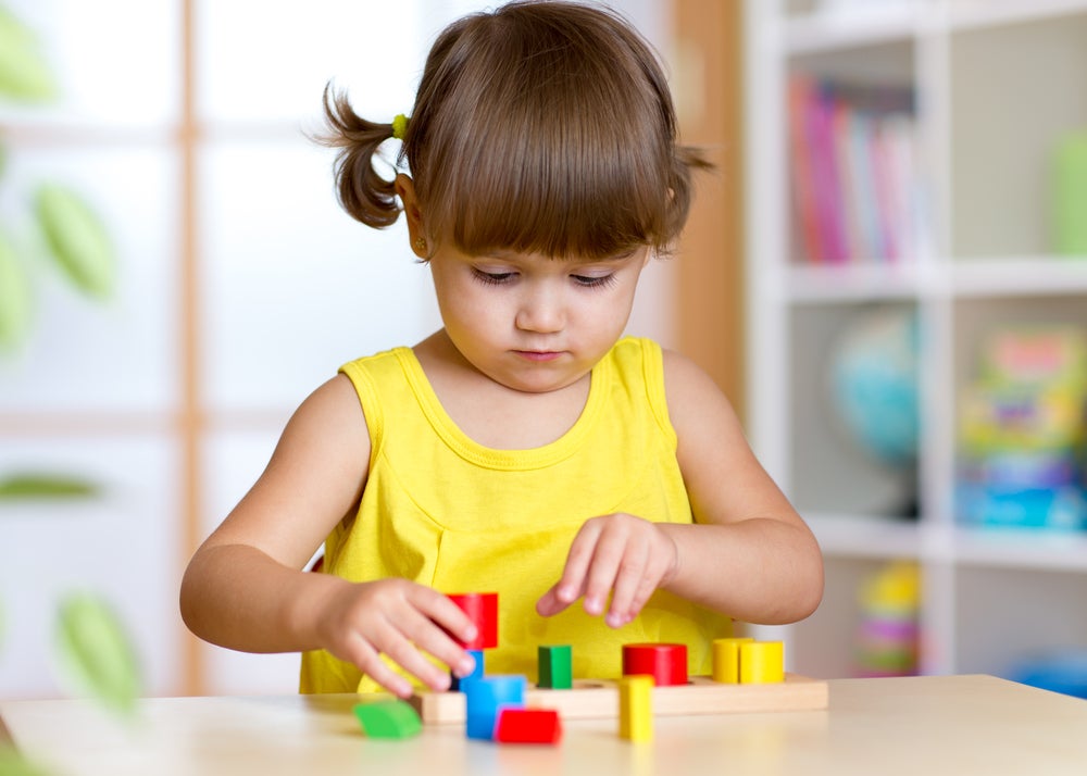 Girl playing with blocks in preschool