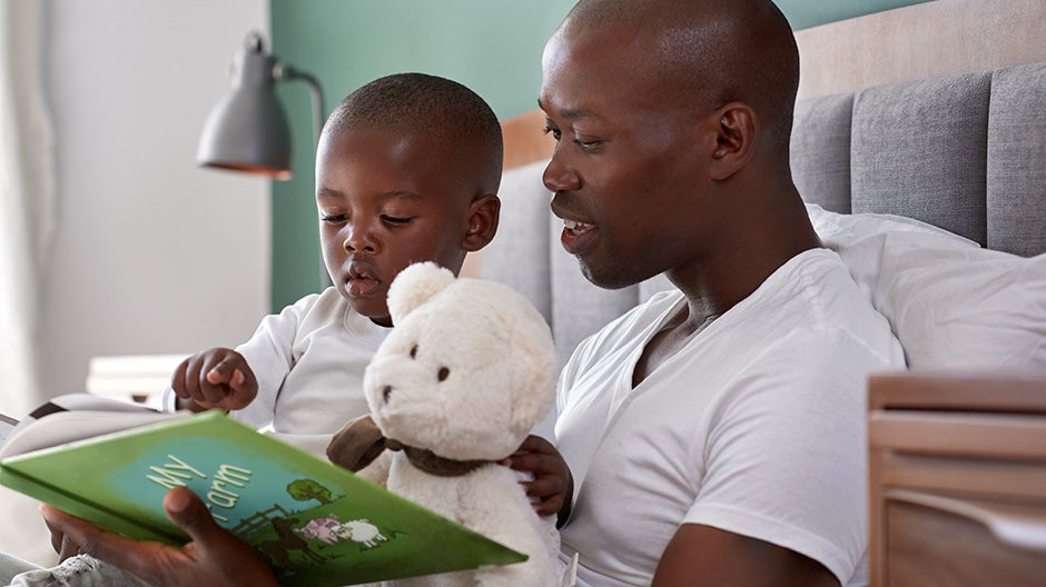 Father reading to child in bed