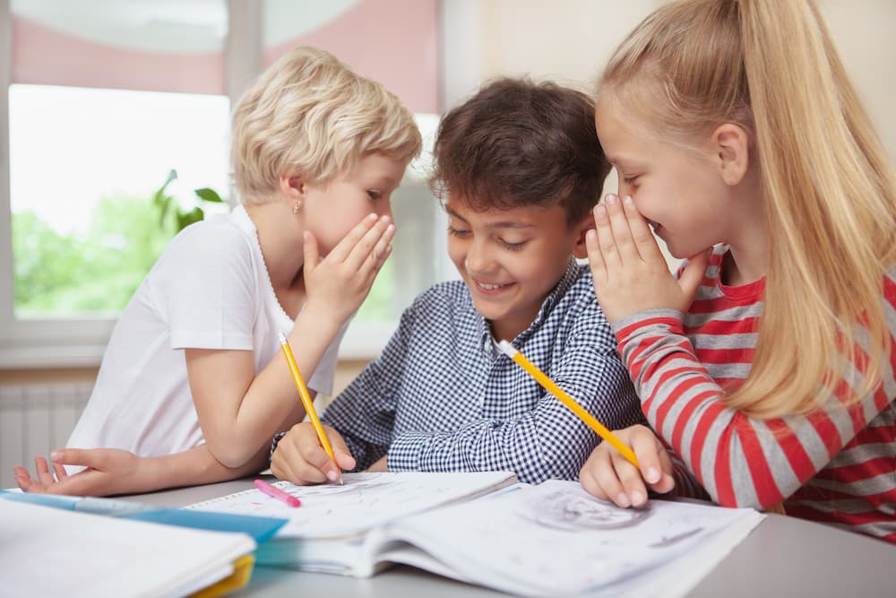 Two girls telling a boy what to draw while playing an art game