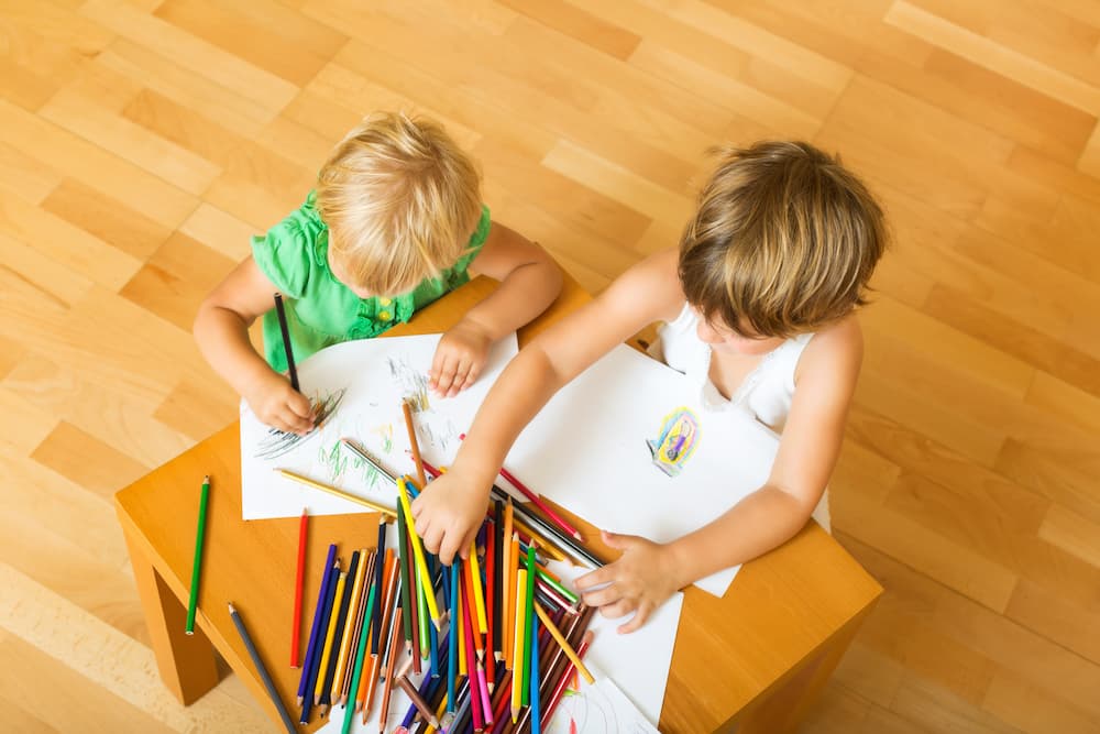 Toddler mimicking older child's drawing while playing art games