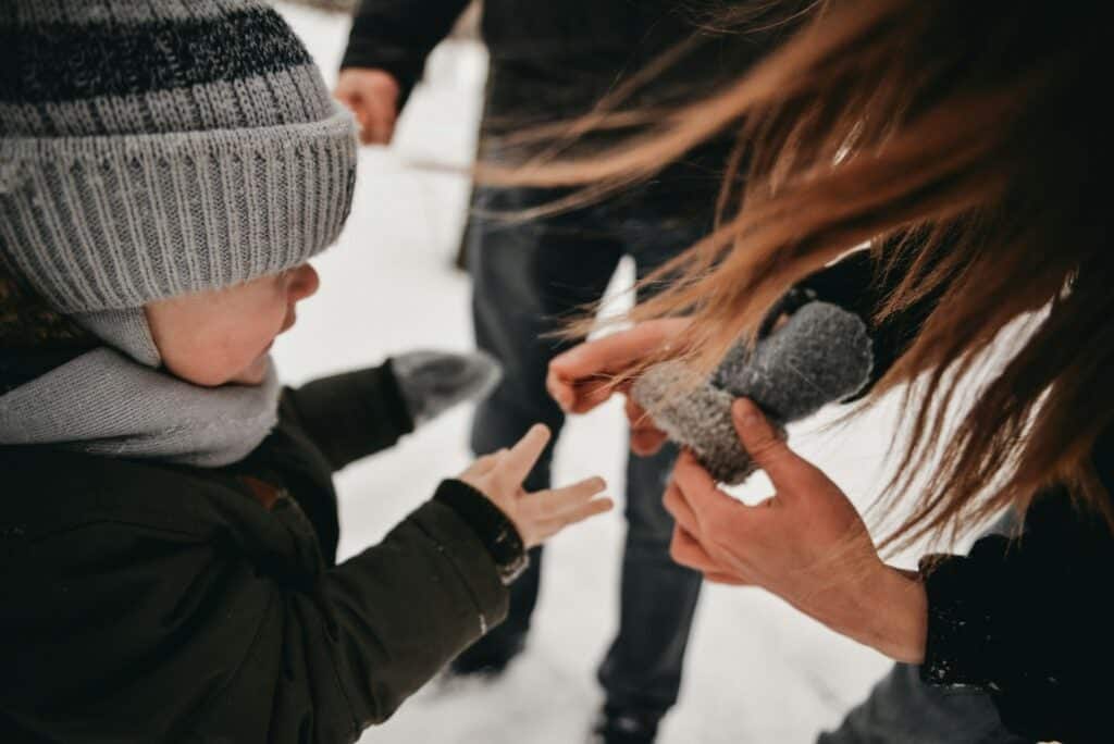 Mom putting dry gloves on kid