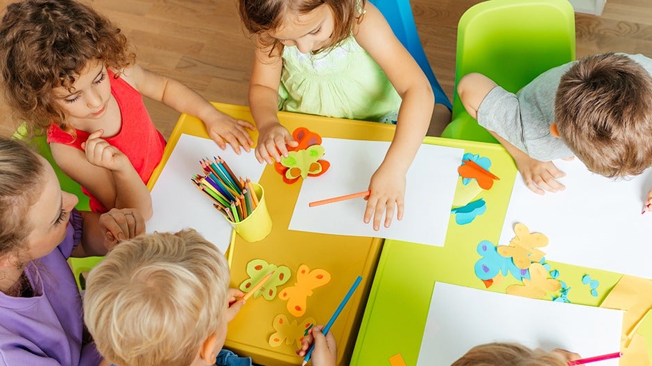 Preschoolers engaged in collaborative arts and crafts activity to develop social skills