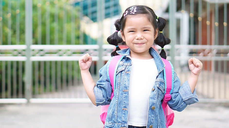 A child girl stands confidently, symbolizing the importance of confidence in children's development.