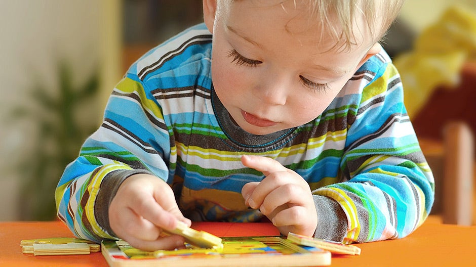 Child doing puzzle as an important part of their early childhood education