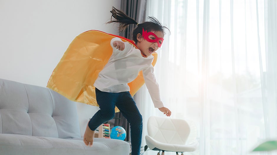 Child playing pretend in a superhero costume to nurture social-emotional skills in early childhood education.