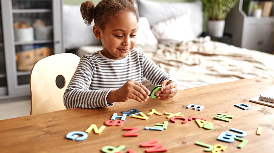 Child playing with foam letters to learn phonemic awareness