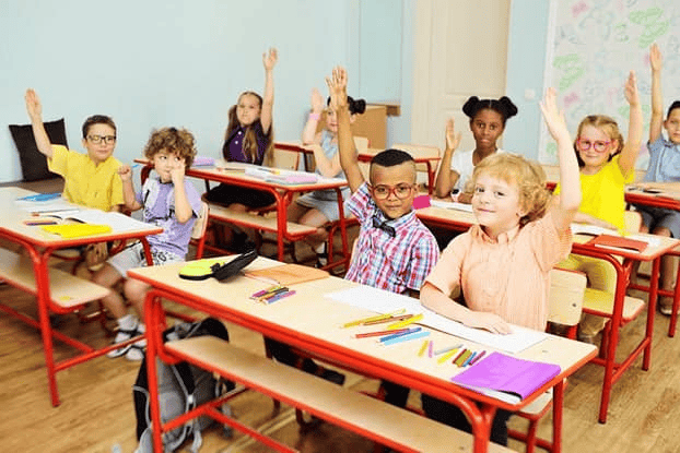kids raising their hands in class
