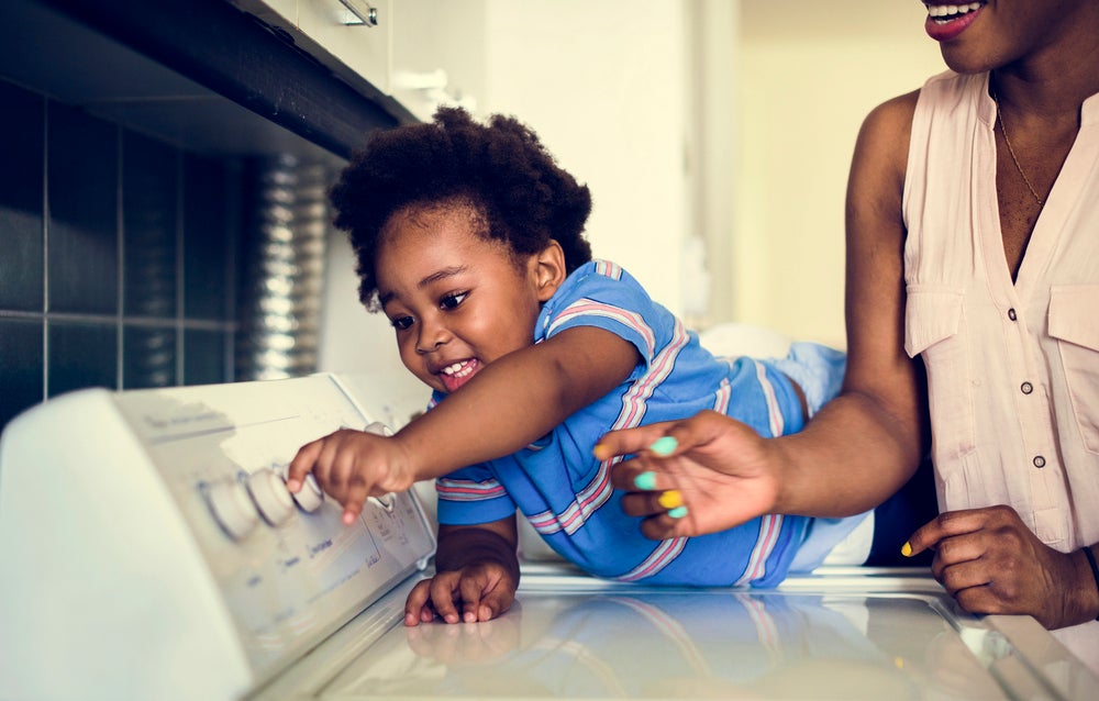 Mom fostering independence with allowing kid to turn knobs on washer machine
