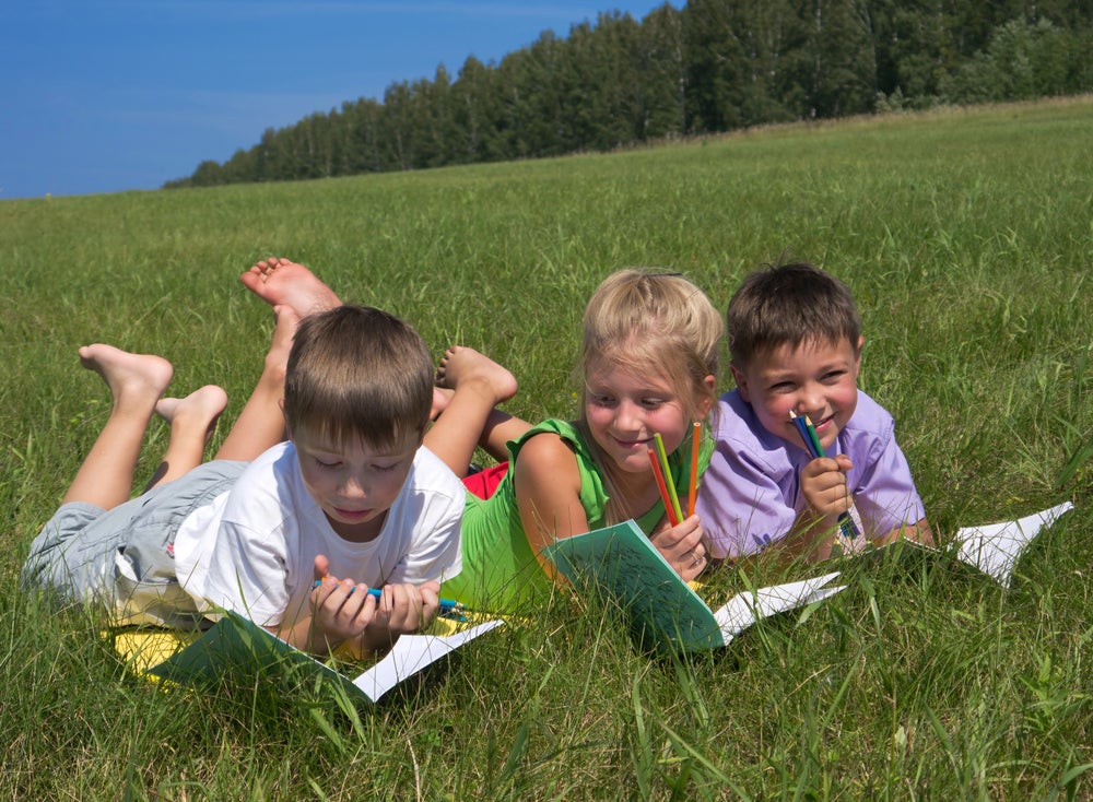 when do kids learn to write - three children writing in the fields