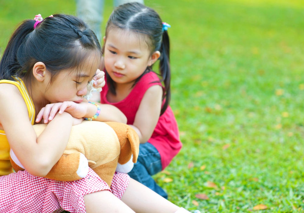 young girl sad with friend comforting her