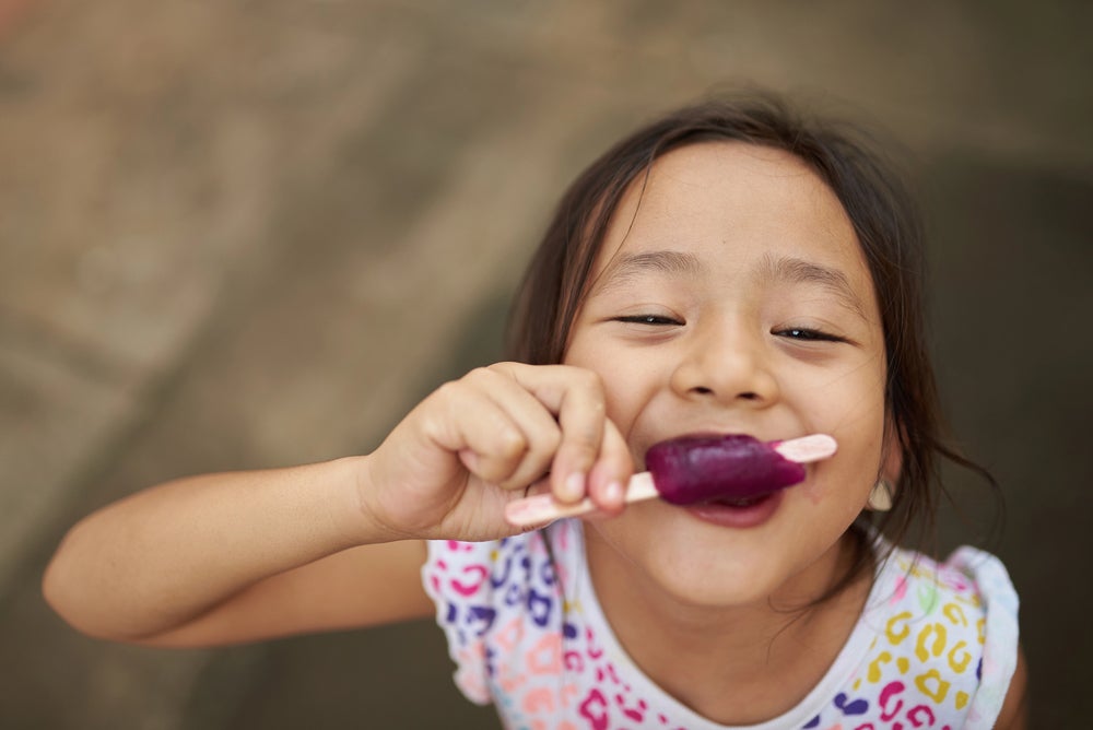 Young girl eating a popsicle