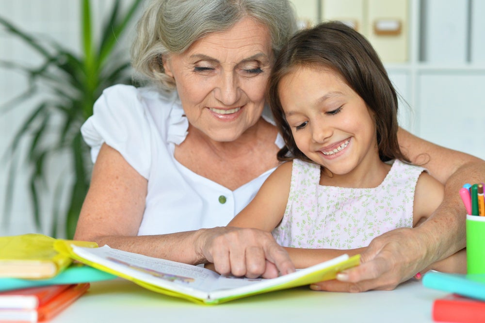 Grandma helping granddaughter with her reading comprehension