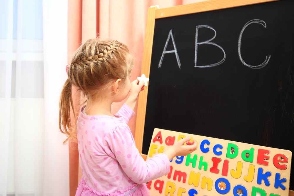 young girl writing words that start with the letter A