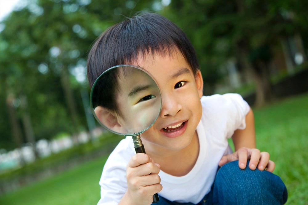kid playing with a magnifying glass
