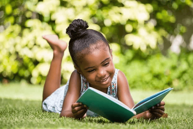 Young girl enjoying reading outside