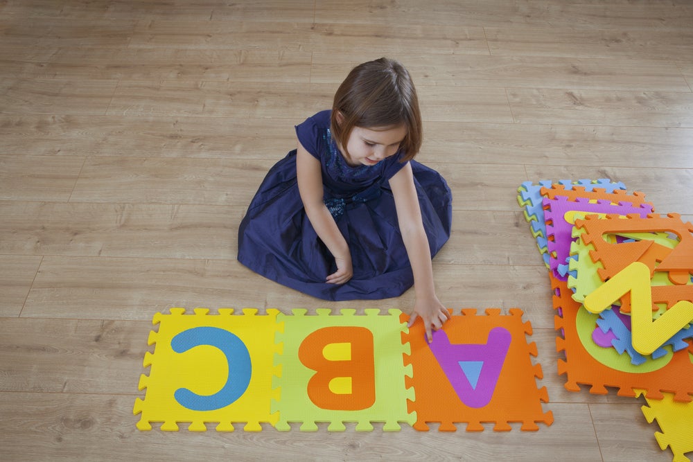 young girl playing with letter toys