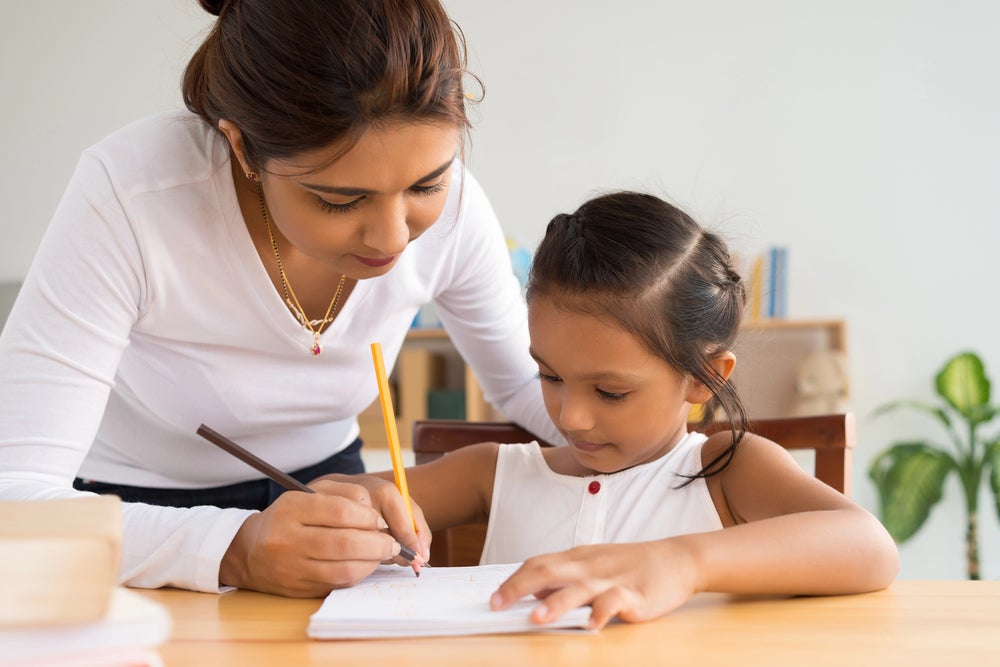 parent helping child practice their handwriting