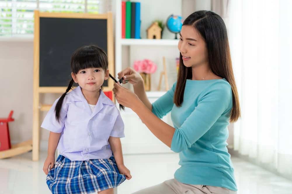 Mom doing daughters hair for her morning routine Mom doing daughters hair for her morning routine
