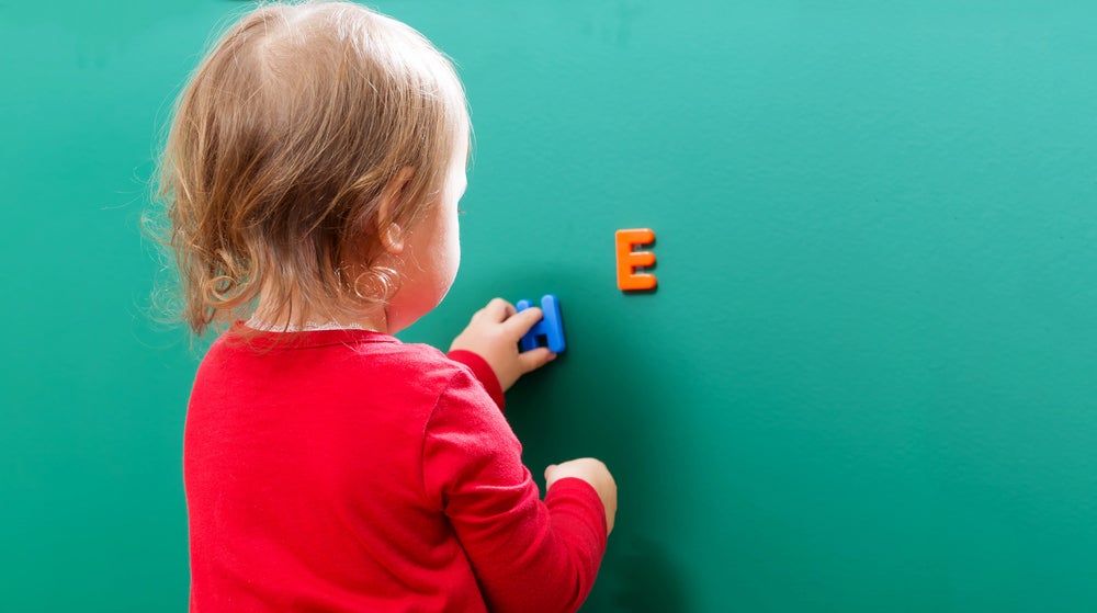preschooler playing with plastic letters