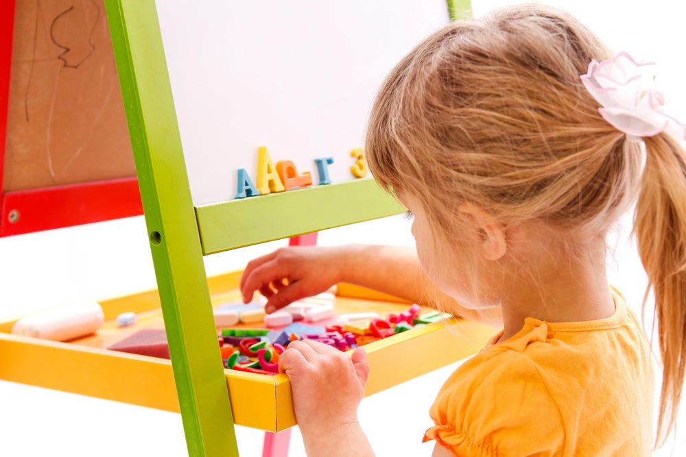 three year old playing with plastic letters