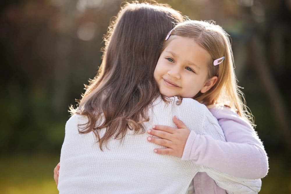 Mom supporting her daughter with a hug