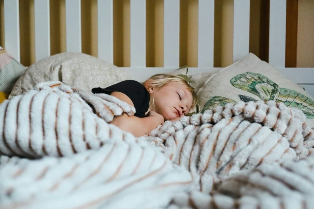 young child sleeping in their bed